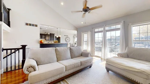a view of a dining room and livingroom with furniture wooden floor a chandelier