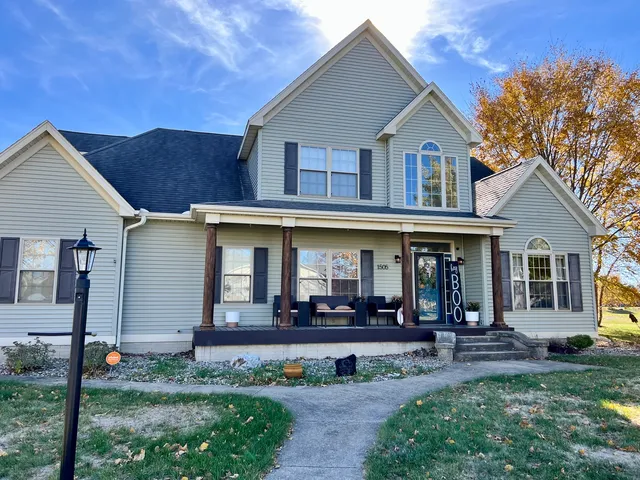 a view of a white house with large windows and a yard