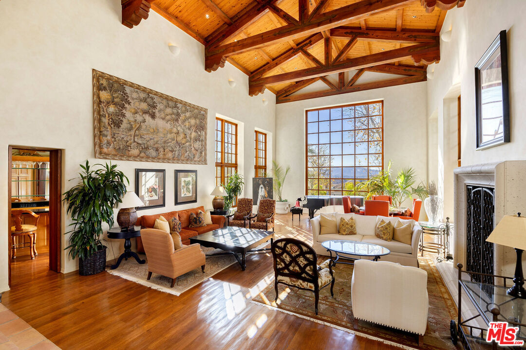 25127 Jim Bridger Road Hidden Hills, CA 91302 - Photo 10 of 50 a living room with fireplace furniture and a large window