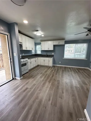 a large kitchen with stainless steel appliances a large counter top and a stove top oven