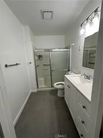 a bathroom with a double vanity sink toilet and shower