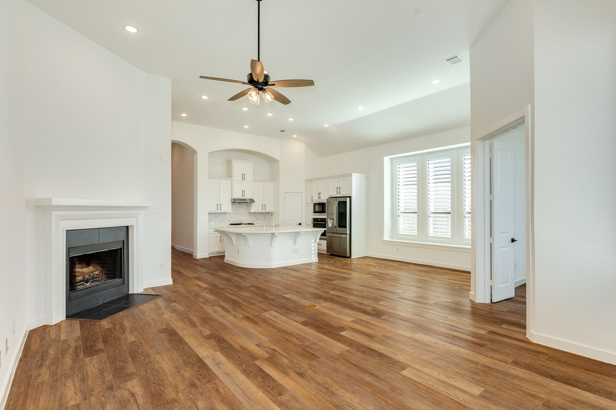 3806 Shackleton Court Rosharon, TX 77583 - Photo 19 of 50 Family area with a wood-burning corner fireplace, recessed lighting, and a ceiling fan that complements the floors and the office to the right.