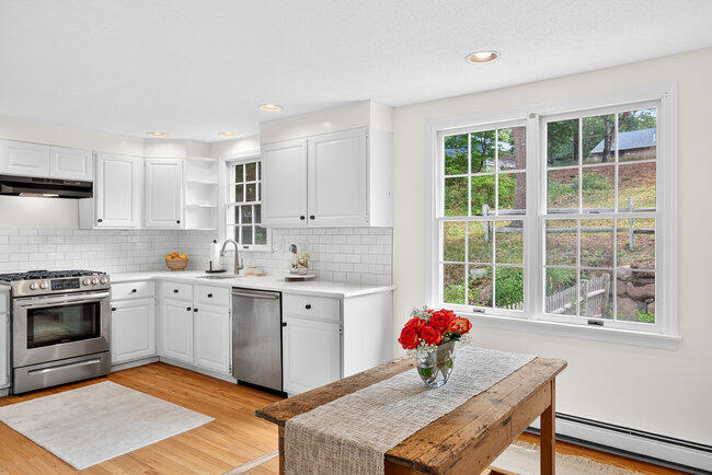 20 Mutiny Way Mashpee, MA 02649 - Photo 11 of 36 a kitchen with stainless steel appliances granite countertop a stove a sink dishwasher and a microwave oven with white cabinets