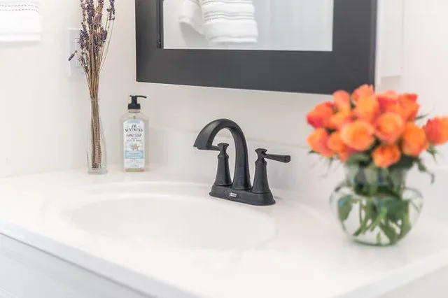 a close view of a sink a mirror and a window