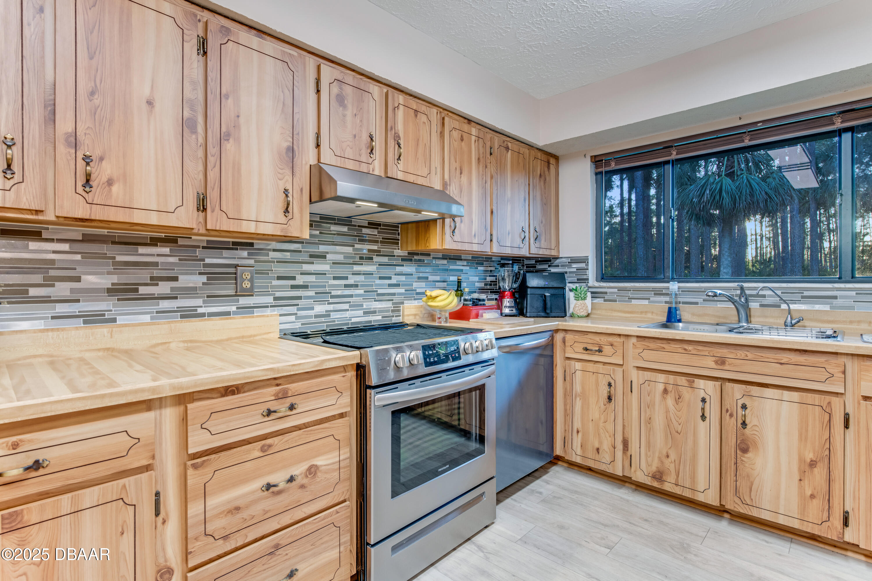46 Winchester Road Ormond Beach, FL 32174 - Photo 25 of 92 a kitchen with granite countertop stainless steel appliances white cabinets granite counter tops and a window