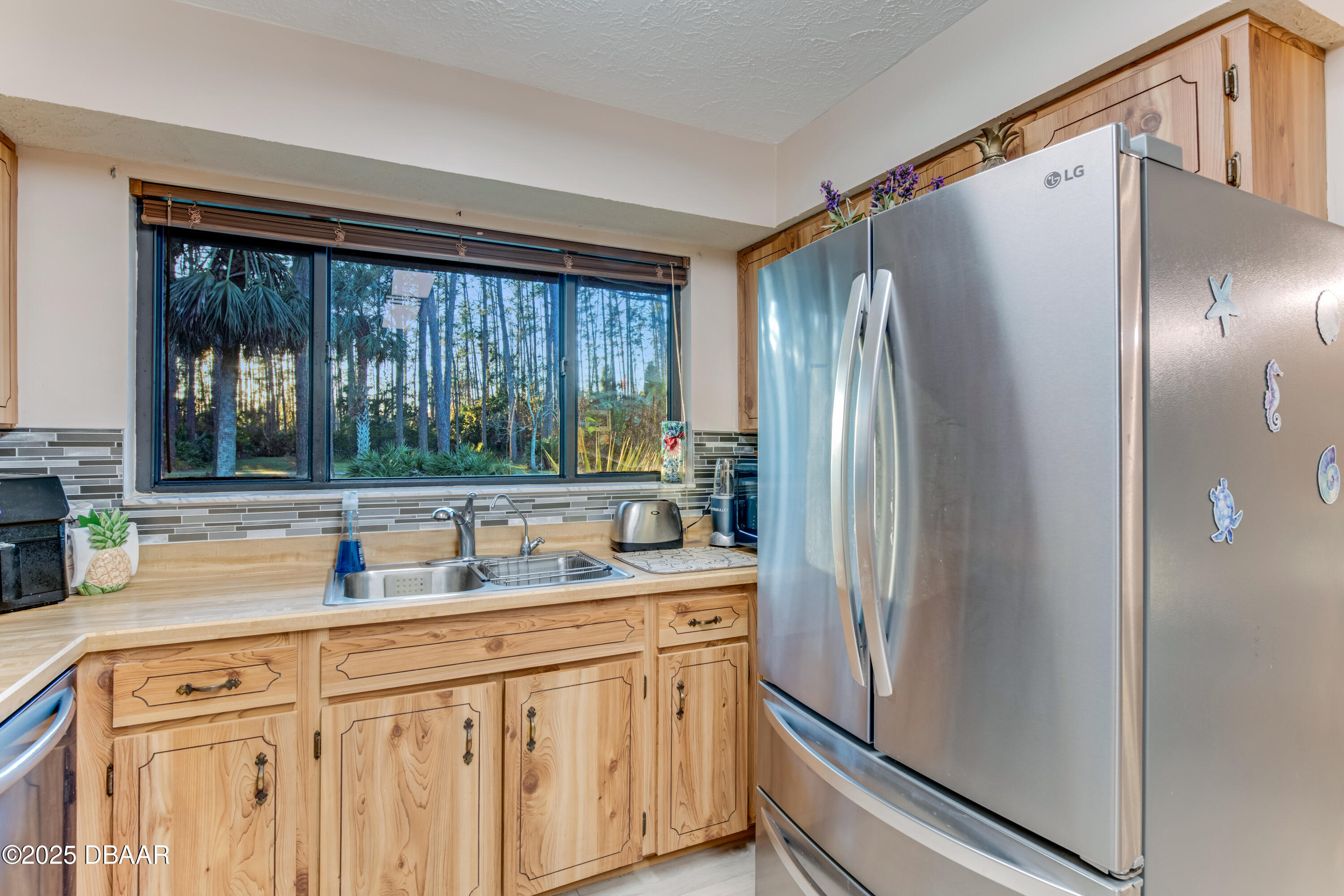 46 Winchester Road Ormond Beach, FL 32174 - Photo 26 of 92 a kitchen with stainless steel appliances granite countertop a refrigerator and a sink