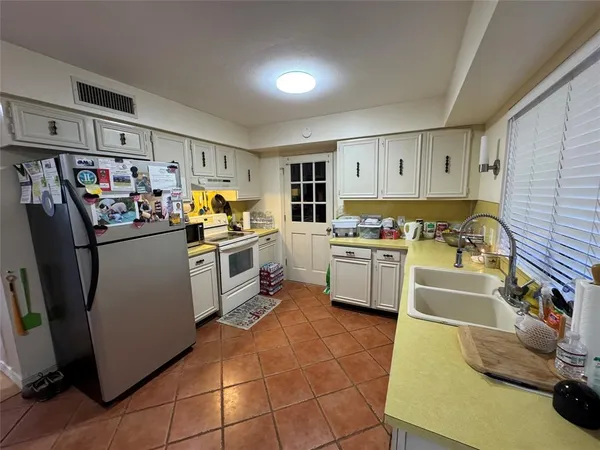 a kitchen with stainless steel appliances a stove a sink and white cabinets