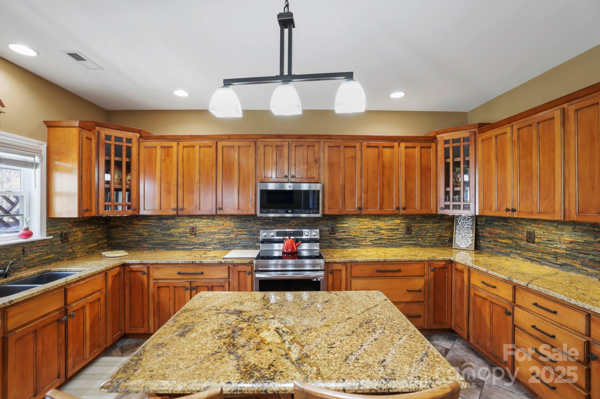 243 Wildbriar Road Fletcher, NC 28732 - Photo 10 of 36 a kitchen with kitchen island granite countertop a sink stove and cabinets