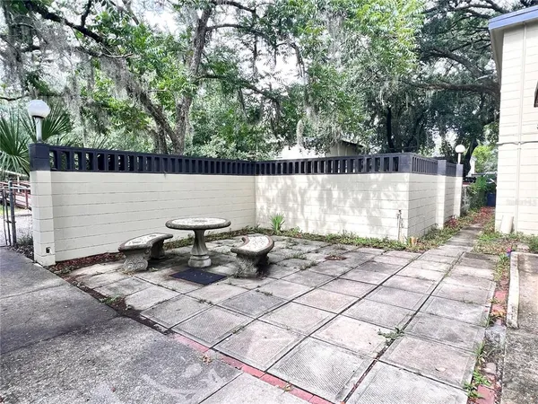 a view of a patio with chairs and potted plants