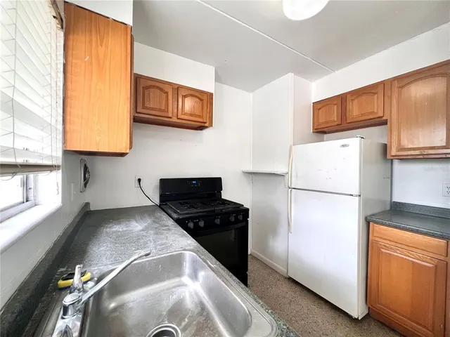 a kitchen with a refrigerator and a stove top oven