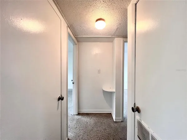 a view of a room with an empty space and a window