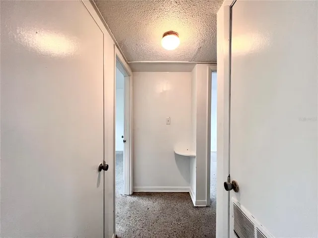 a view of a room with an empty space and a window