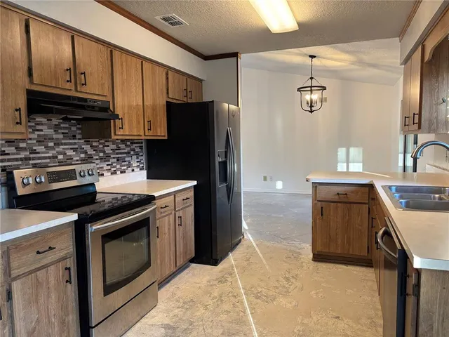 a kitchen with stainless steel appliances granite countertop a stove a refrigerator and a sink