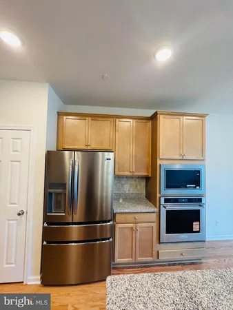 a metallic refrigerator freezer sitting in a kitchen