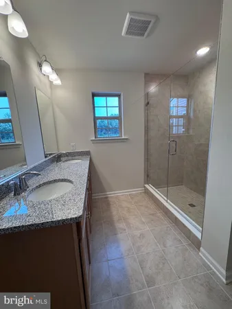 a bathroom with a granite countertop sink a toilet and a mirror