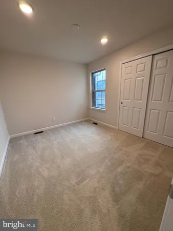 an empty room with windows and ceiling fan