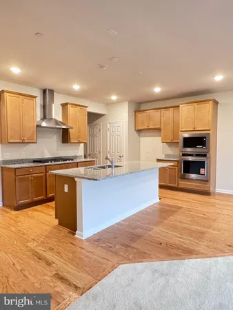 a large kitchen with stainless steel appliances granite countertop a stove a sink and a refrigerator