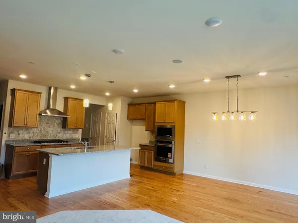 a view of kitchen with kitchen island and stainless steel appliances