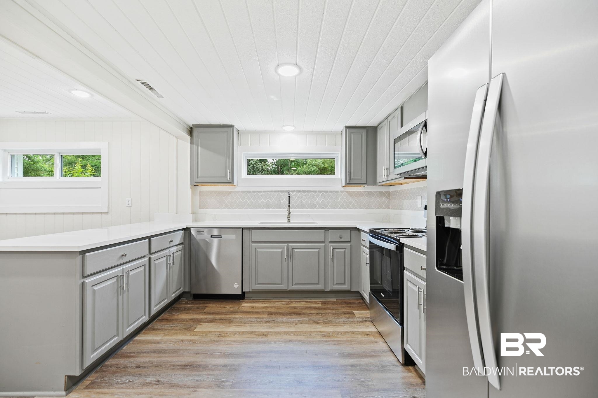 507 Byrne Street Bay Minette, AL 36507 - Photo 8 of 40 Kitchen with decorative backsplash, gray cabinets, stainless steel appliances, and light hardwood / wood-style floors
