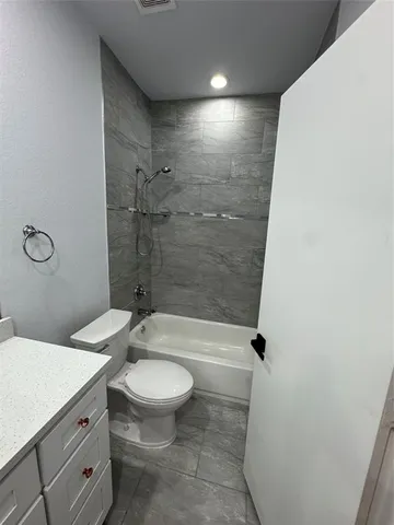 a bathroom with a granite countertop sink a toilet and shower