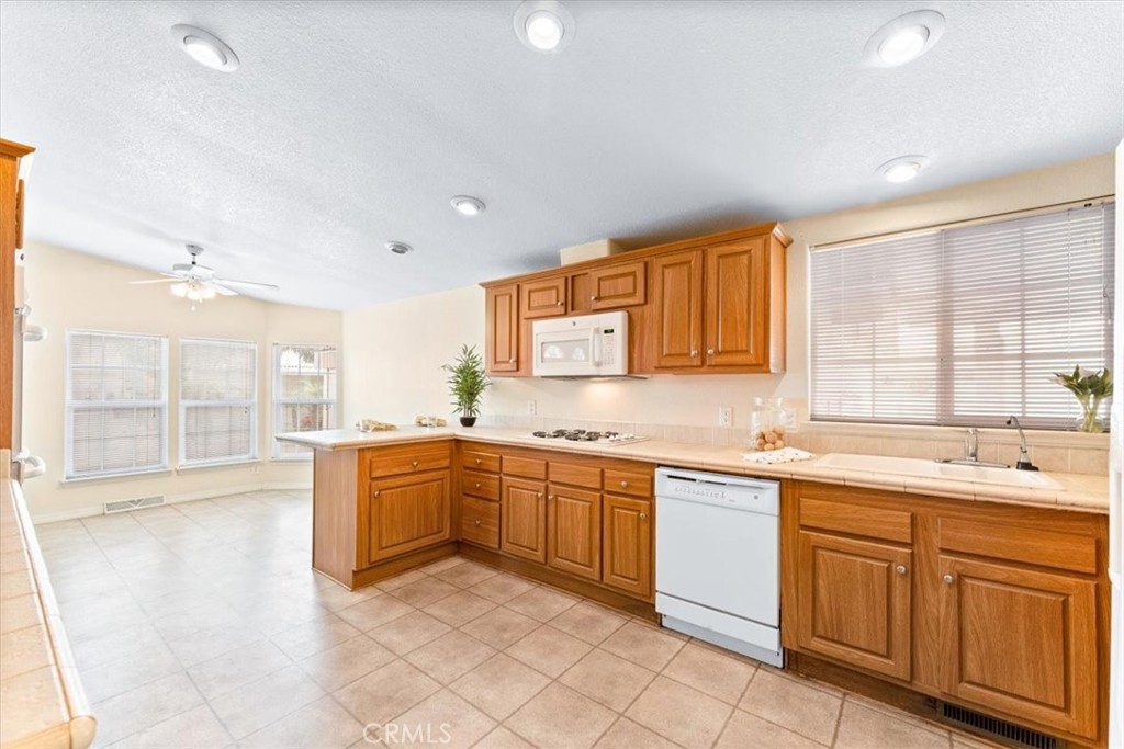 32 Pine Via Anaheim, CA 92801 - Photo 14 of 19 a large kitchen with kitchen island granite countertop a sink and white cabinets
