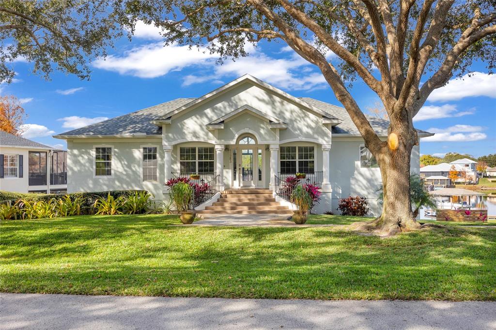 11243 Preston Cove Road Clermont, FL 34711 - Photo 13 of 72 a front view of a house with a garden and trees