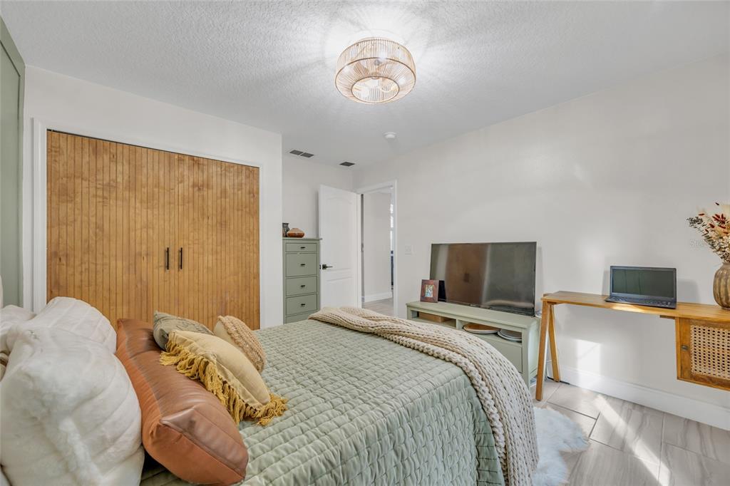 11243 Preston Cove Road Clermont, FL 34711 - Photo 20 of 72 a bedroom with a bed and a flat screen tv