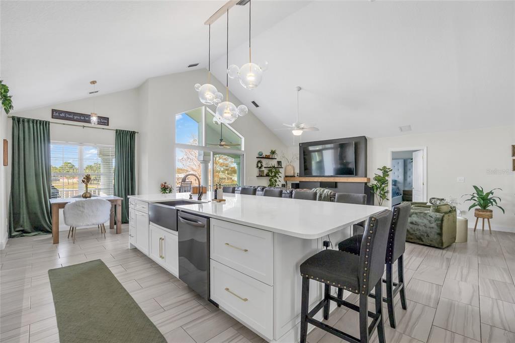 11243 Preston Cove Road Clermont, FL 34711 - Photo 26 of 72 a large kitchen with kitchen island a dining table and chairs