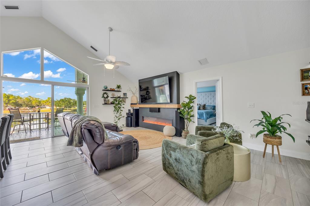 11243 Preston Cove Road Clermont, FL 34711 - Photo 28 of 72 a living room with furniture a chandelier and a flat screen tv