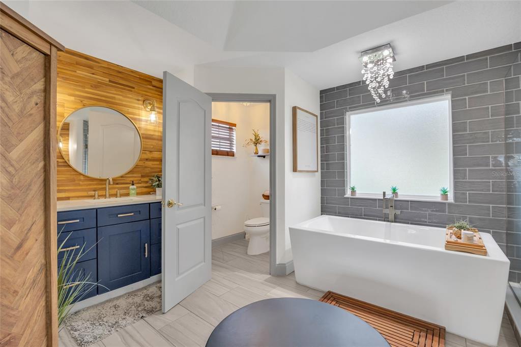 11243 Preston Cove Road Clermont, FL 34711 - Photo 46 of 72 a bathroom with a tub sink and mirror