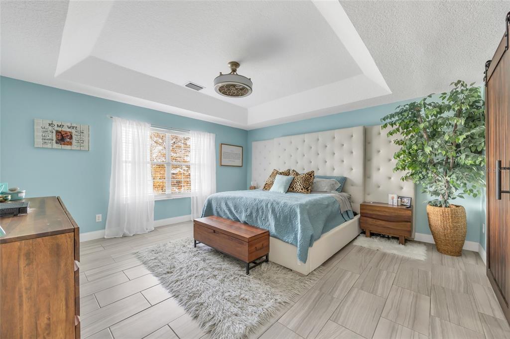 11243 Preston Cove Road Clermont, FL 34711 - Photo 47 of 72 a spacious bedroom with a bed and a window