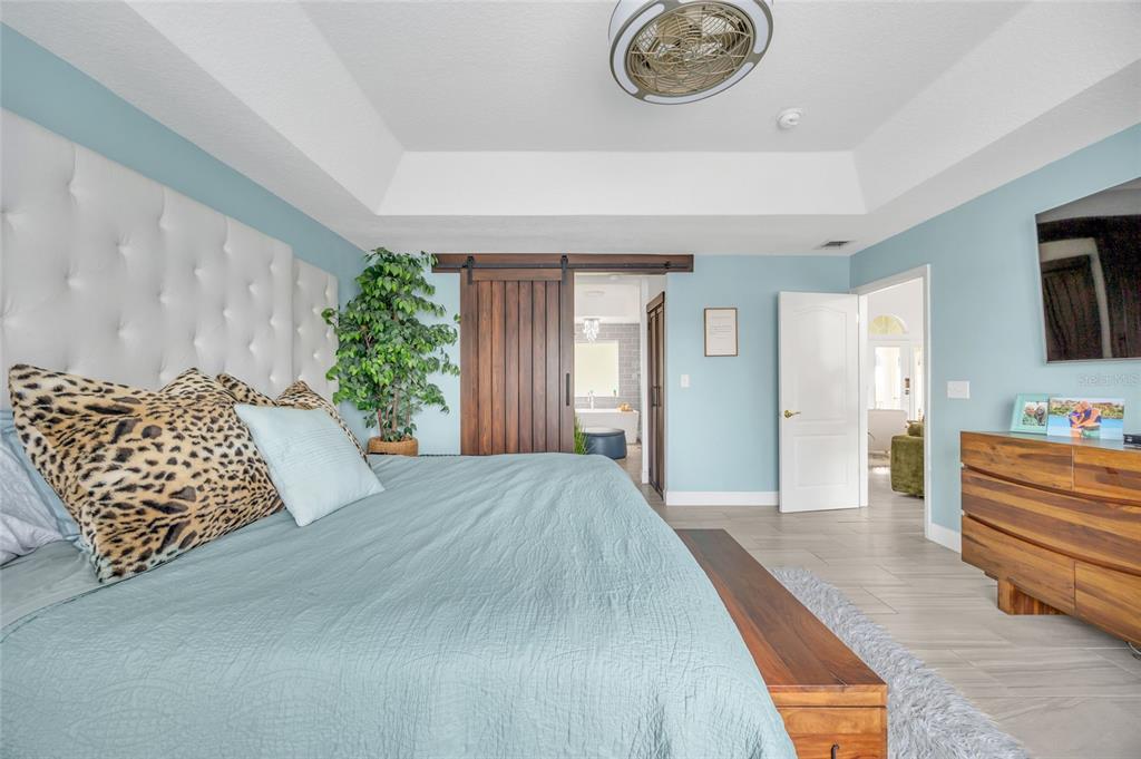 11243 Preston Cove Road Clermont, FL 34711 - Photo 48 of 72 a bedroom with a bed and a chandelier