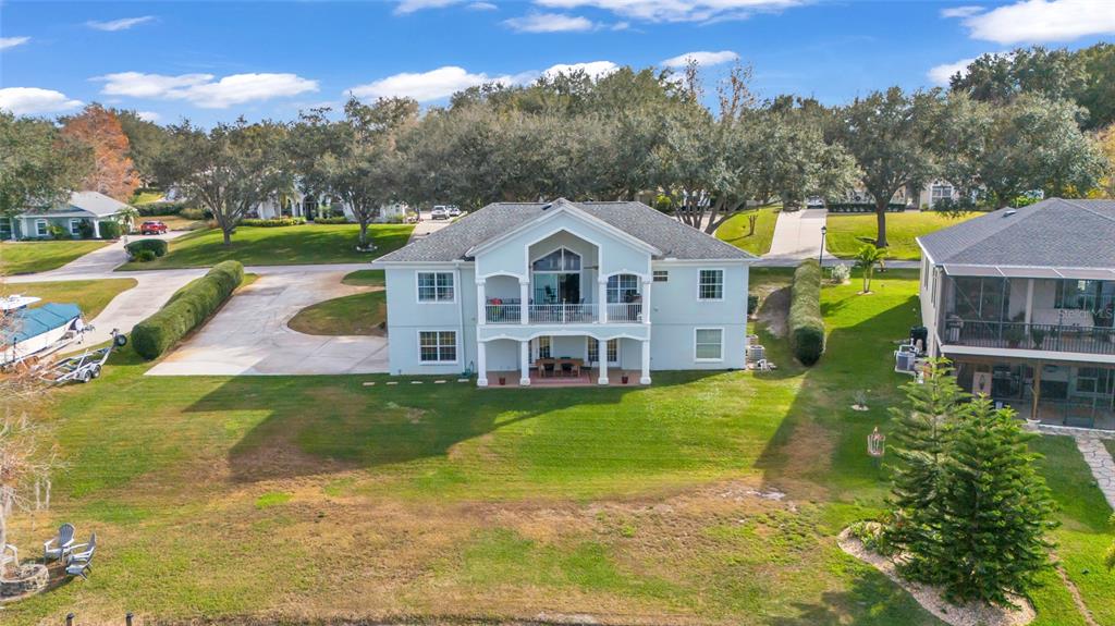 11243 Preston Cove Road Clermont, FL 34711 - Photo 60 of 72 a view of a big house with a big yard and large trees
