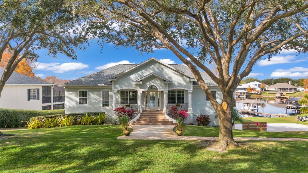 11243 Preston Cove Road Clermont, FL 34711 - Photo 66 of 72 a front view of a house with garden and trees