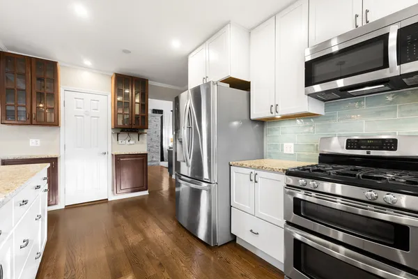 a kitchen with stainless steel appliances and wooden floor