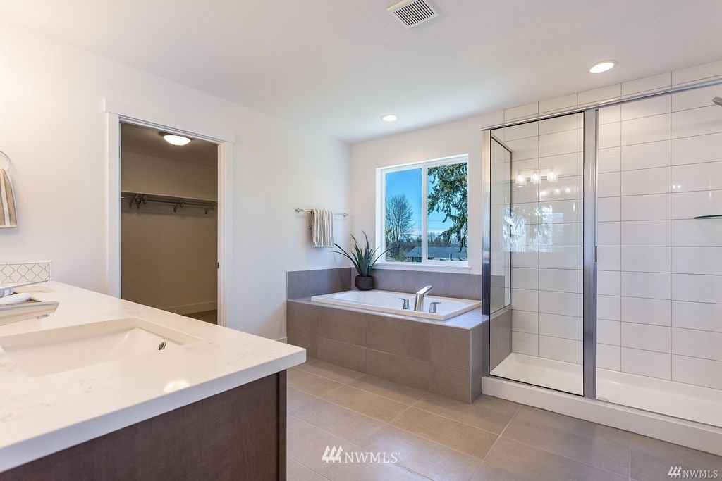 4900 Northeast 1st Street Renton, WA 98059 - Photo 10 of 14 a spacious bathroom with a tub a mirror and a shower