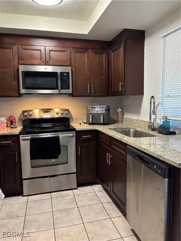 a kitchen with granite countertop a stove top oven microwave and cabinets