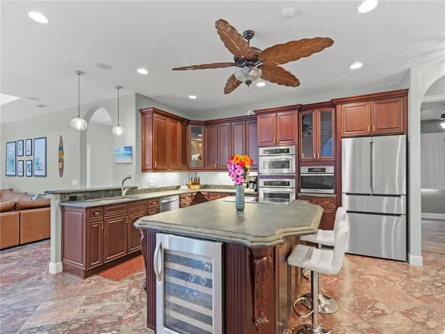 a kitchen with stainless steel appliances granite countertop a sink a stove and a refrigerator