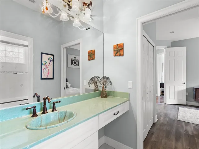a bathroom with a granite countertop sink a mirror and vanity