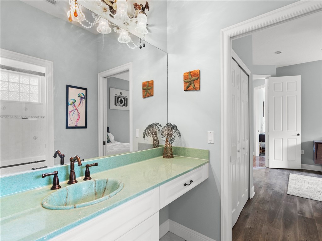 4676 Pebble Bay South, Unit BAY Vero Beach, FL 32963 - Photo 25 of 36 a bathroom with a granite countertop sink a mirror and vanity