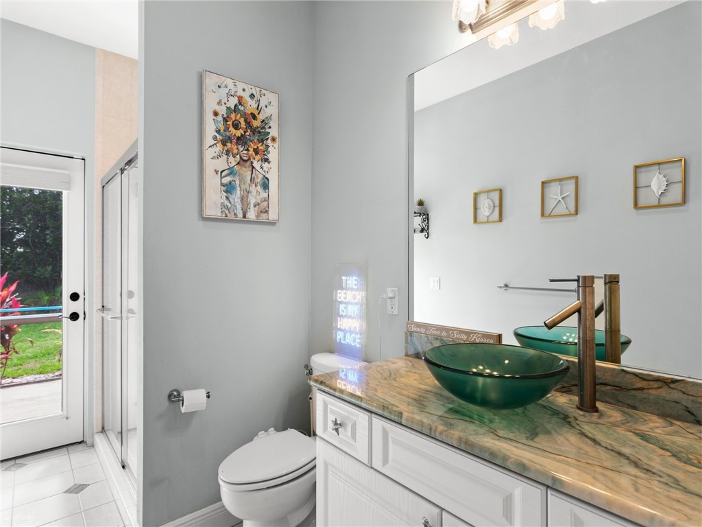4676 Pebble Bay South, Unit BAY Vero Beach, FL 32963 - Photo 29 of 36 a spacious bathroom with a granite countertop sink and a toilet