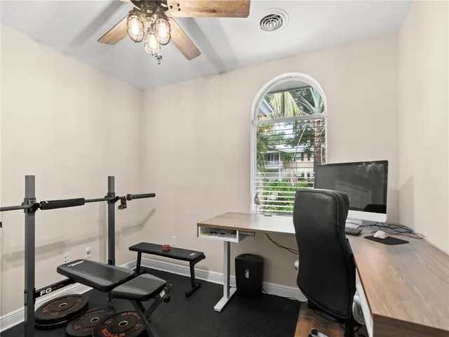 a view of a workspace with furniture and a window