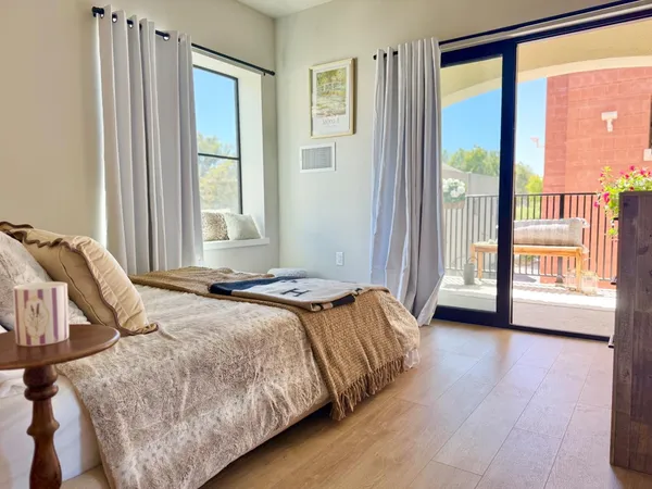 a bedroom with a bed and a large window with outer view