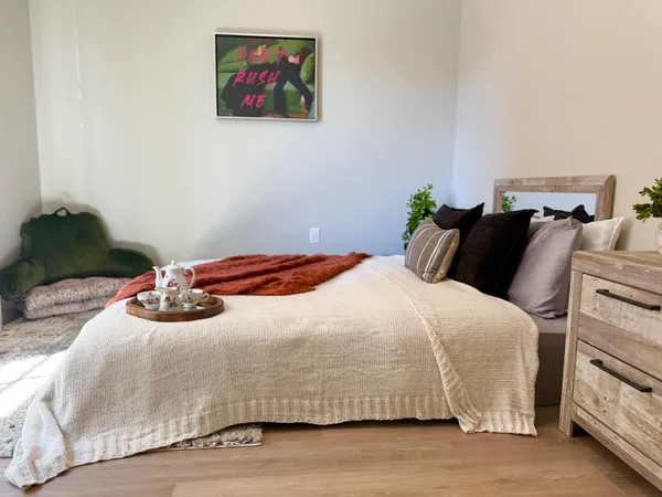a bedroom with a bed and a painting on the wall