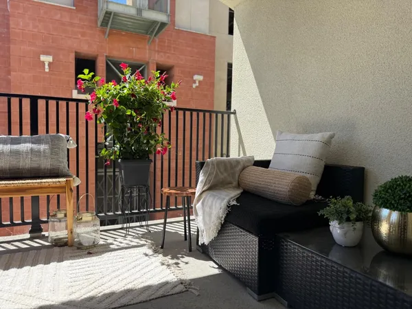 a view of a balcony with chairs potted plants