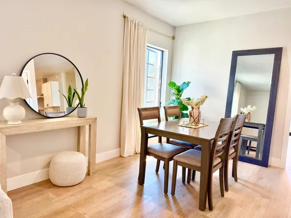a dining room with furniture and a potted plant