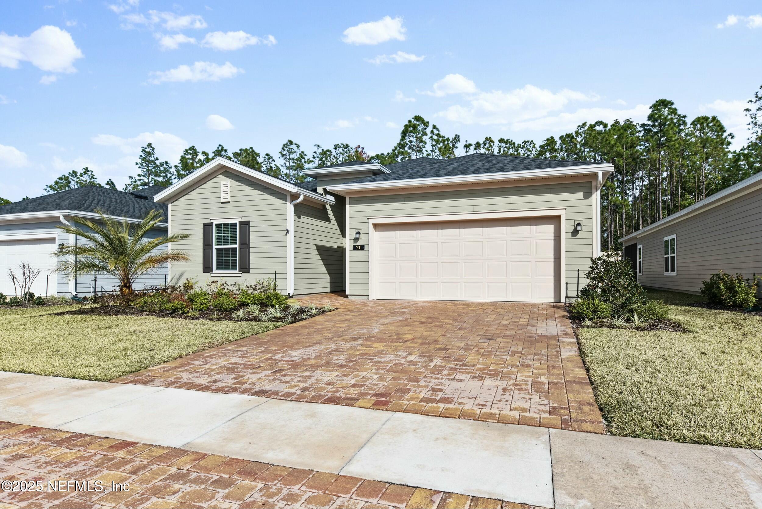 71 Blue Cypress Trail St. Augustine, FL 32084 - Photo 2 of 28 a front view of a house with a yard and garage