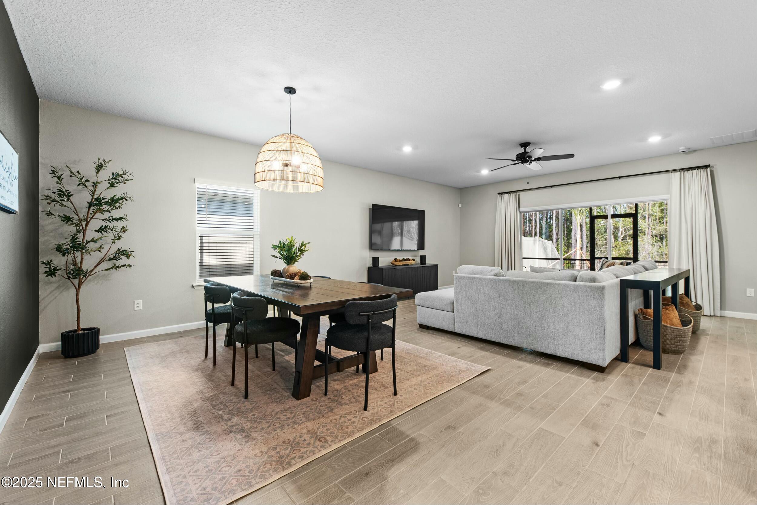 71 Blue Cypress Trail St. Augustine, FL 32084 - Photo 6 of 28 a living room with furniture a dining table and a chandelier