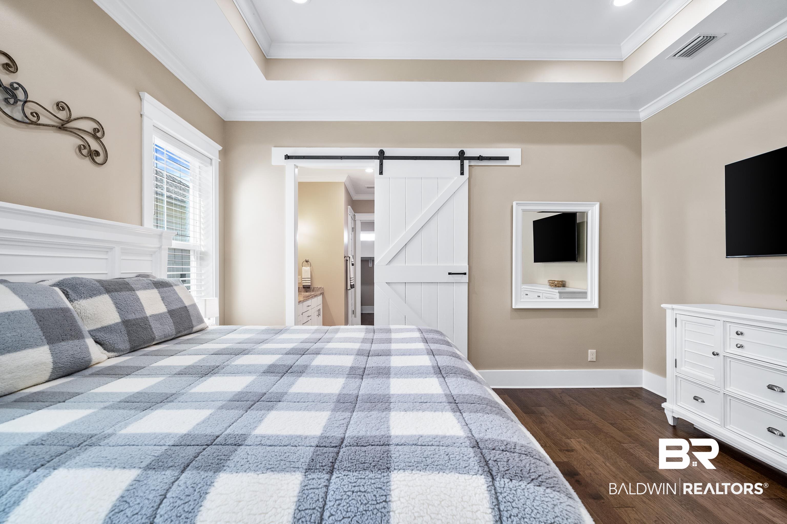 1018 Snapdragon Lane Foley, AL 36535 - Photo 22 of 37 Bedroom featuring dark hardwood / wood-style flooring, ensuite bath, ornamental molding, a tray ceiling, and a barn door