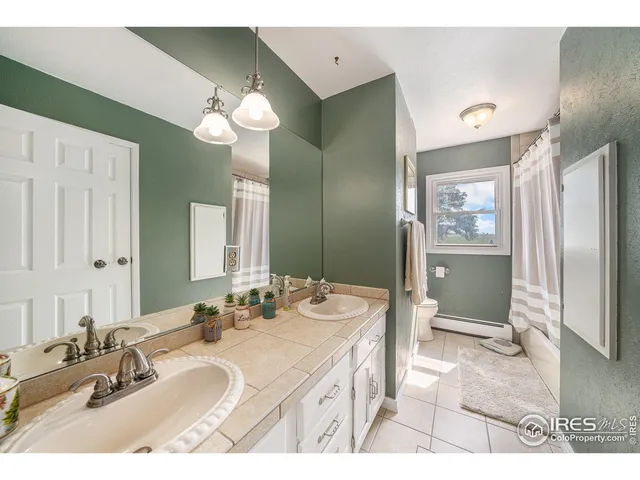 a bathroom with a sink double vanity granite and a shower